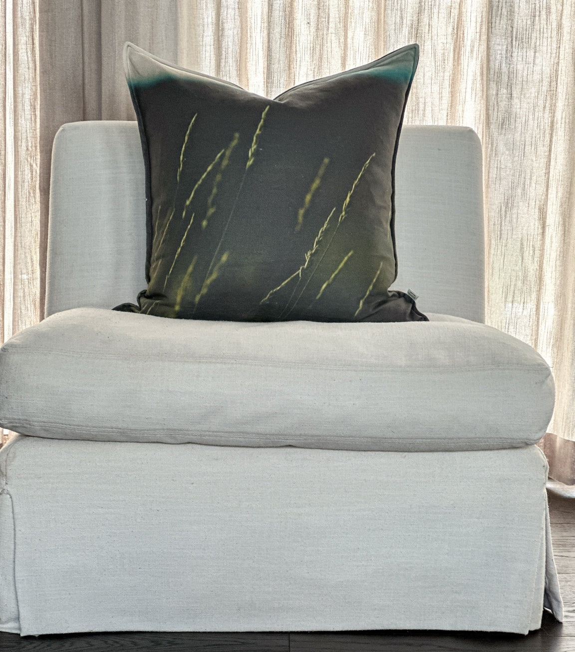 Styled Indian Ricegrass linen pillow — botanical Utah design on a neutral chair