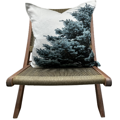 Blue Spruce pillow on modern woven wood chair — Utah evergreen design on natural linen