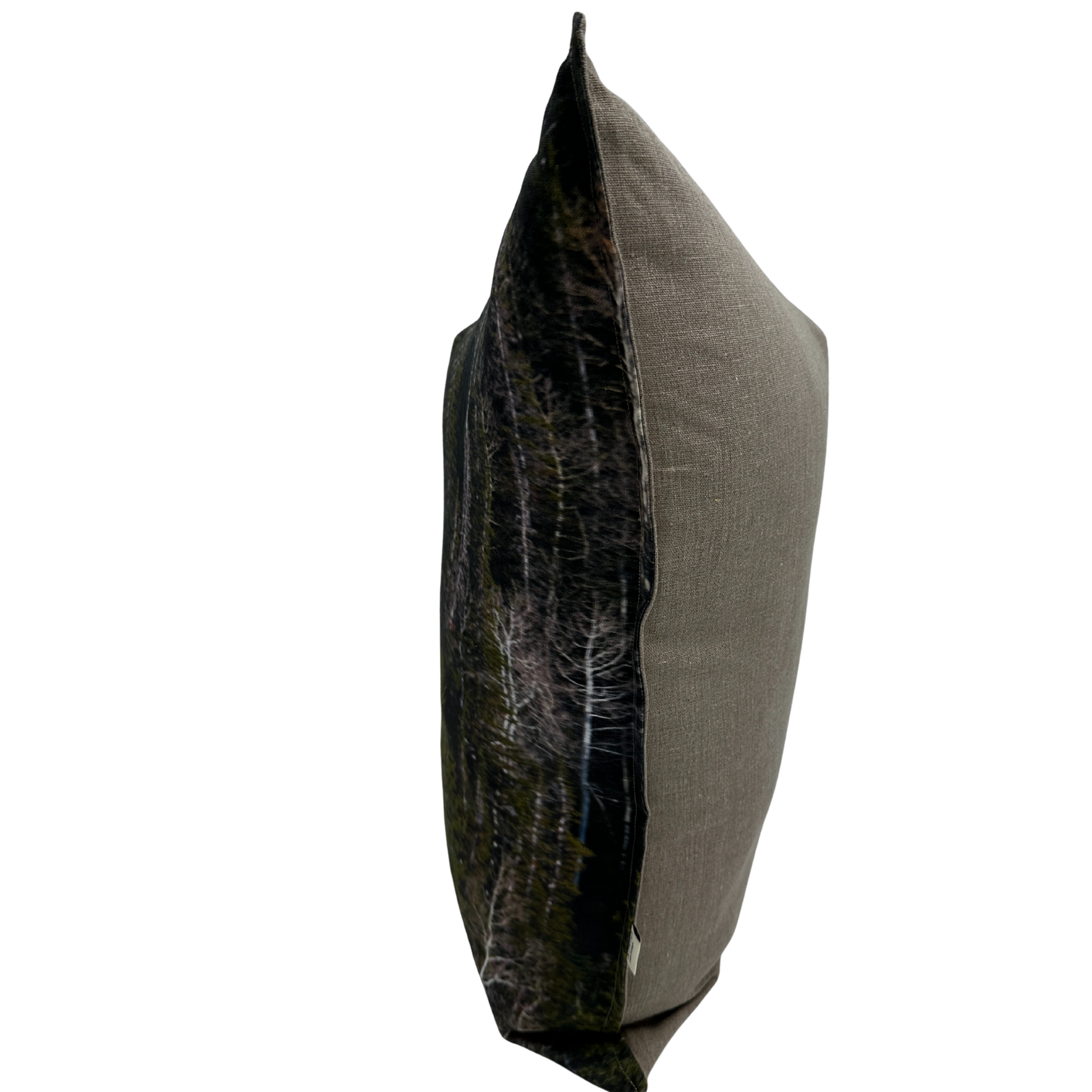 Side view of the Evergreen pillow showing the forest print and natural linen texture