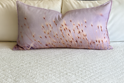 Prairie Grass linen pillow on a white bed, featuring soft golden Utah grass design