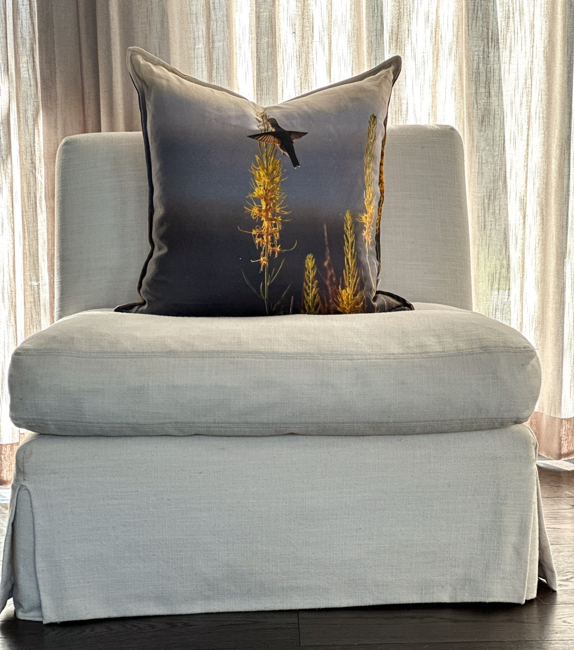 Prince’s Plume linen pillow styled on a neutral chair with golden Utah wildflowers and a hummingbird